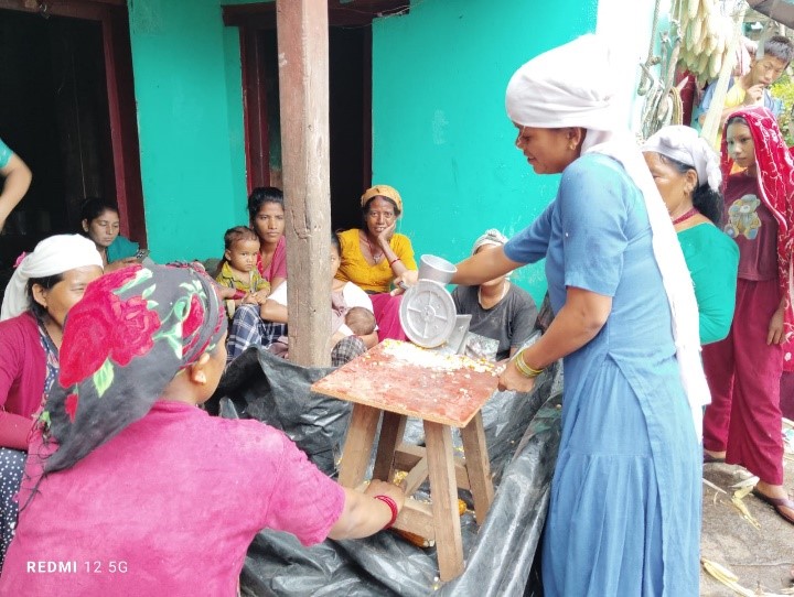 Women farmers using corn seller